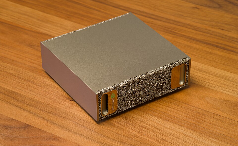 NVIDIA DGX Spark desktop AI computer, gold metal-foam chassis, oblique view on a wooden table